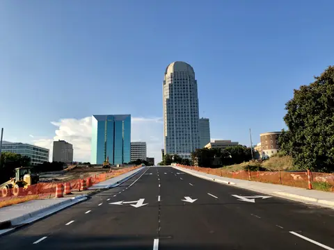 A road leading into downtown Winston-Salem, its towers ahead